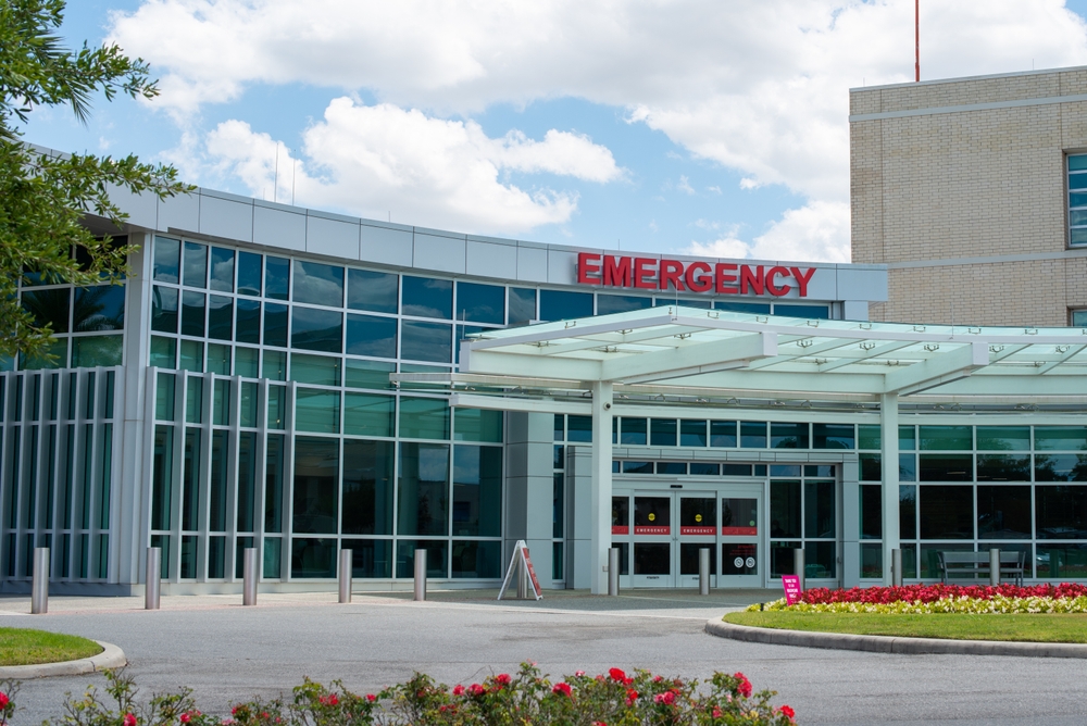 nurses and elderly outside of the hospital with well-maintained grass