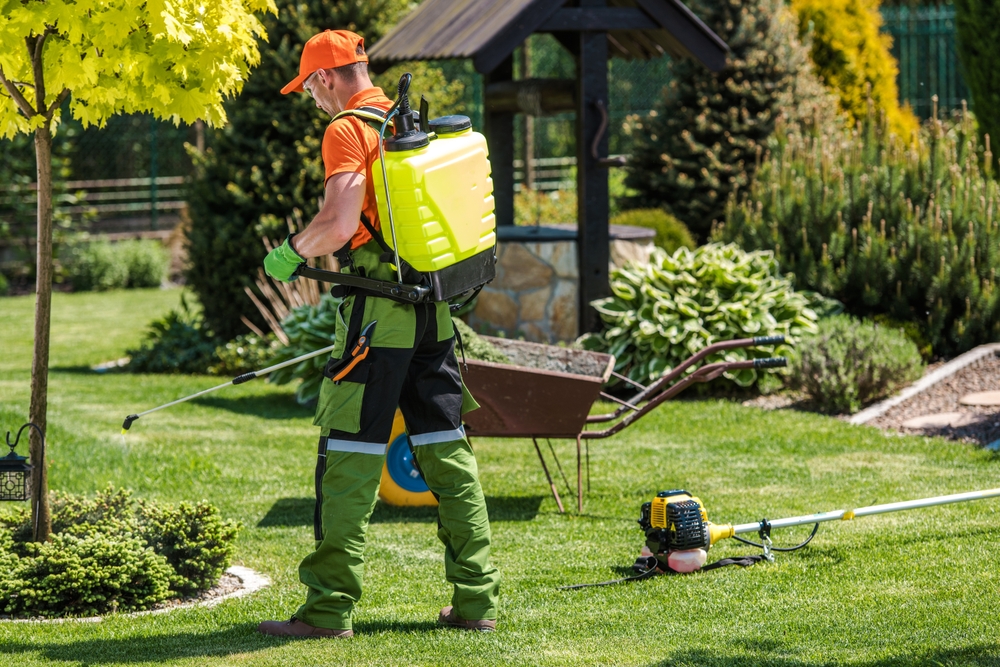 landscaper doing pest control for commercial lawn maintenance